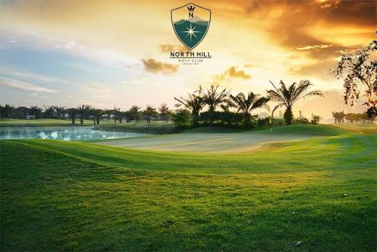 North Hill Chiang Mai Golf Club at sunset, looking across the water to a green